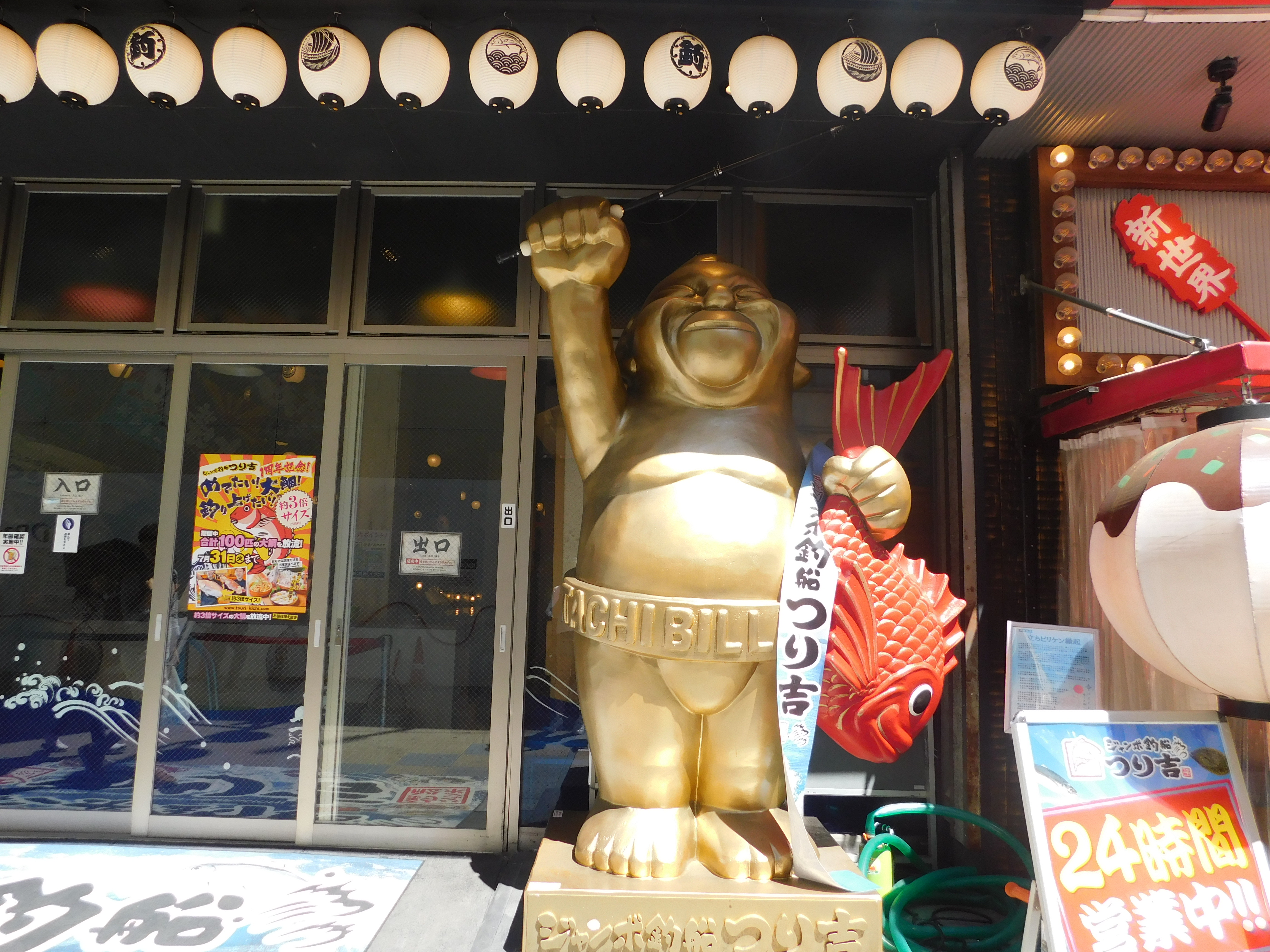 Bronze Buddha-like statue in front of a restaurant